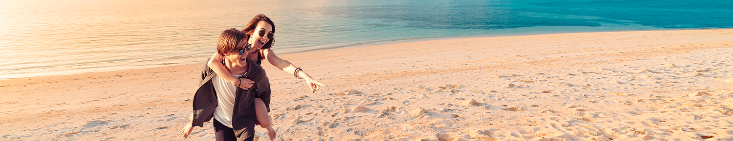 guy and girl on the beach wearing sunglasses